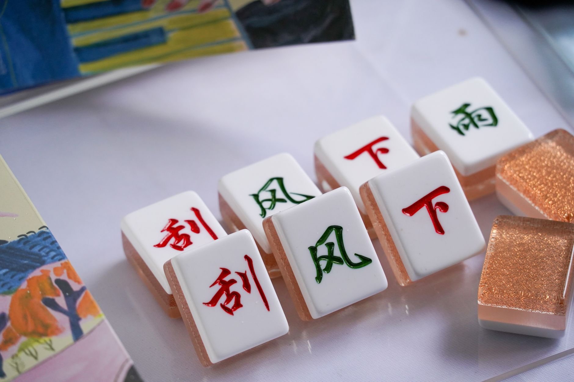 Mahjong tiles arranged on a warm wooden table in afternoon light